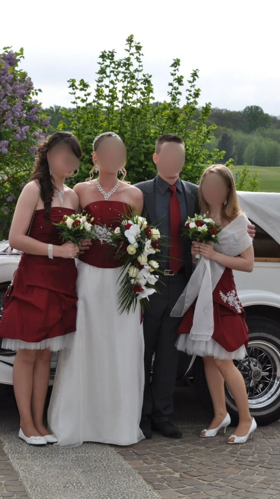 Sortie de mariage : les mariés et leurs invitées, voiture blanche en arrière-plan