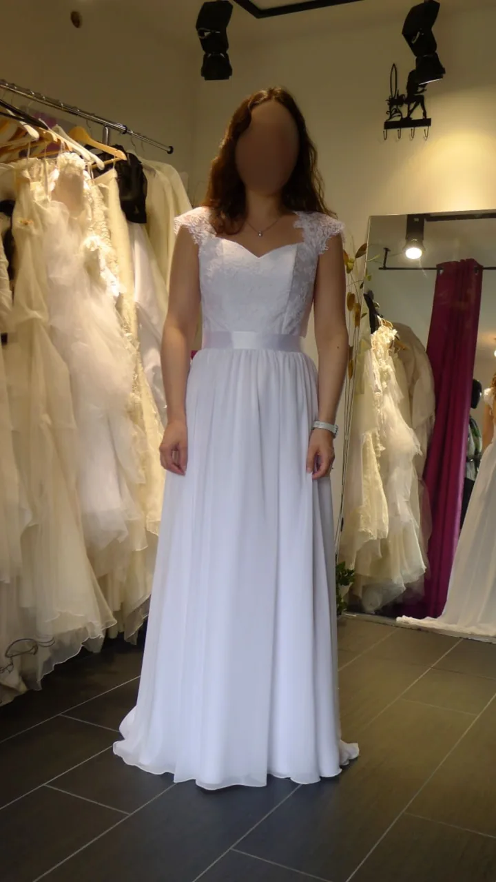 Robe de mariée ligne A : corsage en dentelle, manches papillon, ceinture satin et jupe fluide à l'essayage