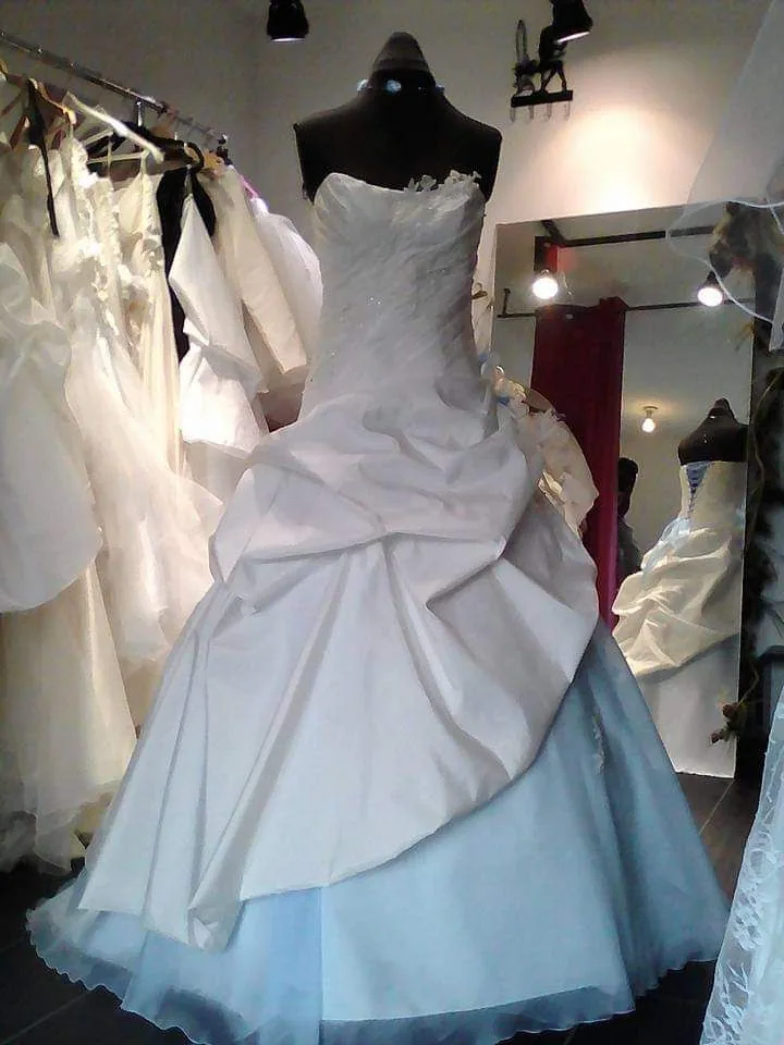 Robe de mariée bustier à jupe drapée en satin blanc avec dessous de tulle bleu pâle, sur buste de couture