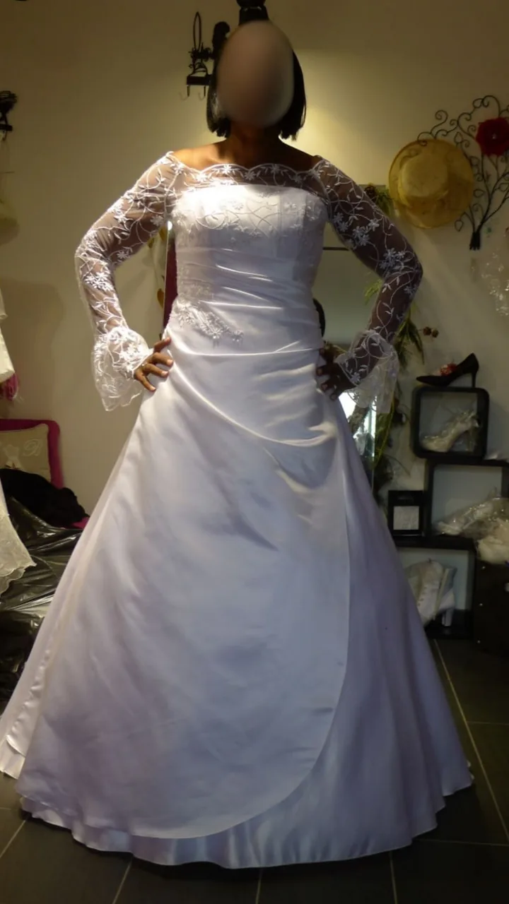 Robe de mariée en satin ligne A : manches longues transparentes brodées et poignets évasés, jupe drapée